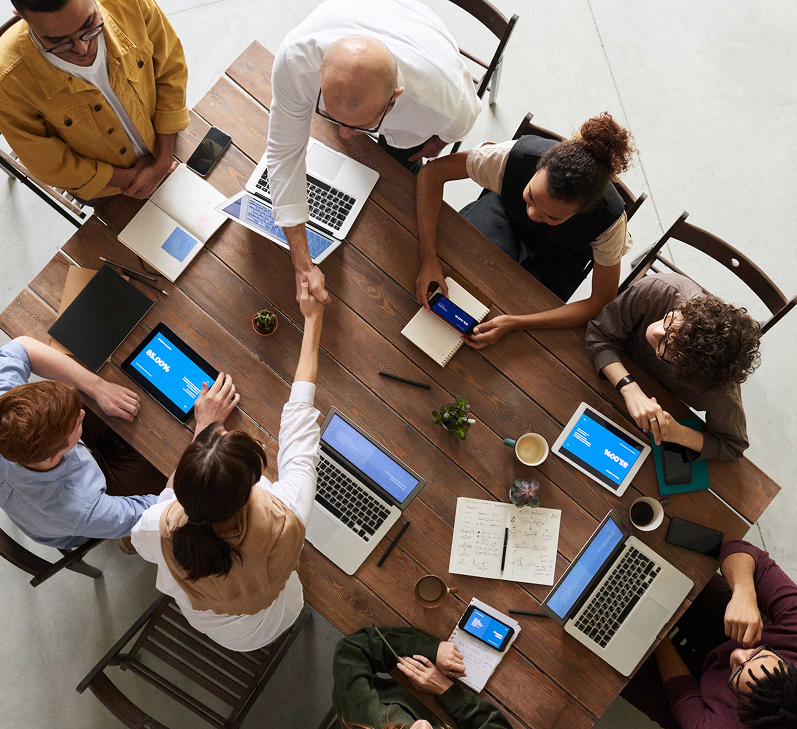 We boost our clients a group of people around a table with laptops